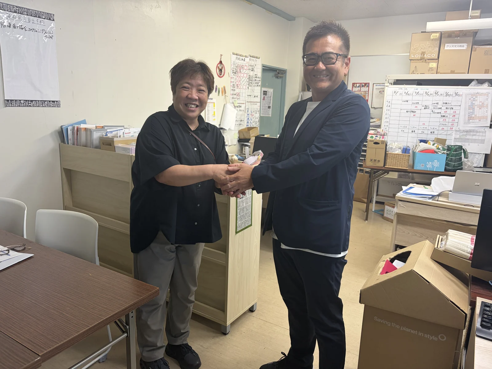 ナチュラルハートフルケアネットワークの下元佳子代表と握手を交わすリナシェンテ代表取締役 川平泰雅
